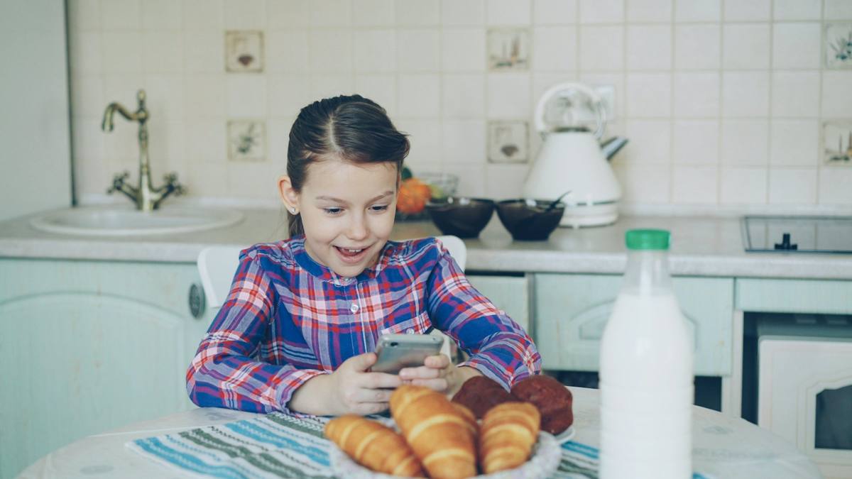 Kid texting at breakfast